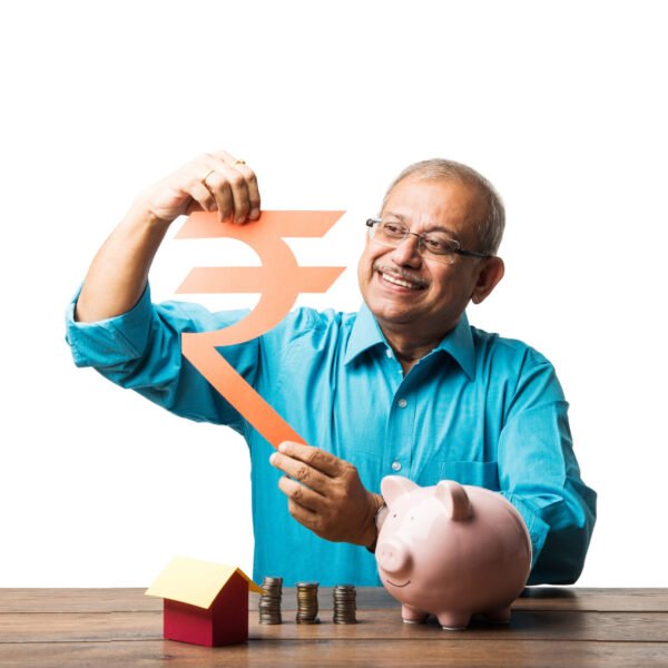 senior Indian asian man and savings concept - with piggy bank, currency notes, 3d house model, money fan, pile of coins. sitting at table